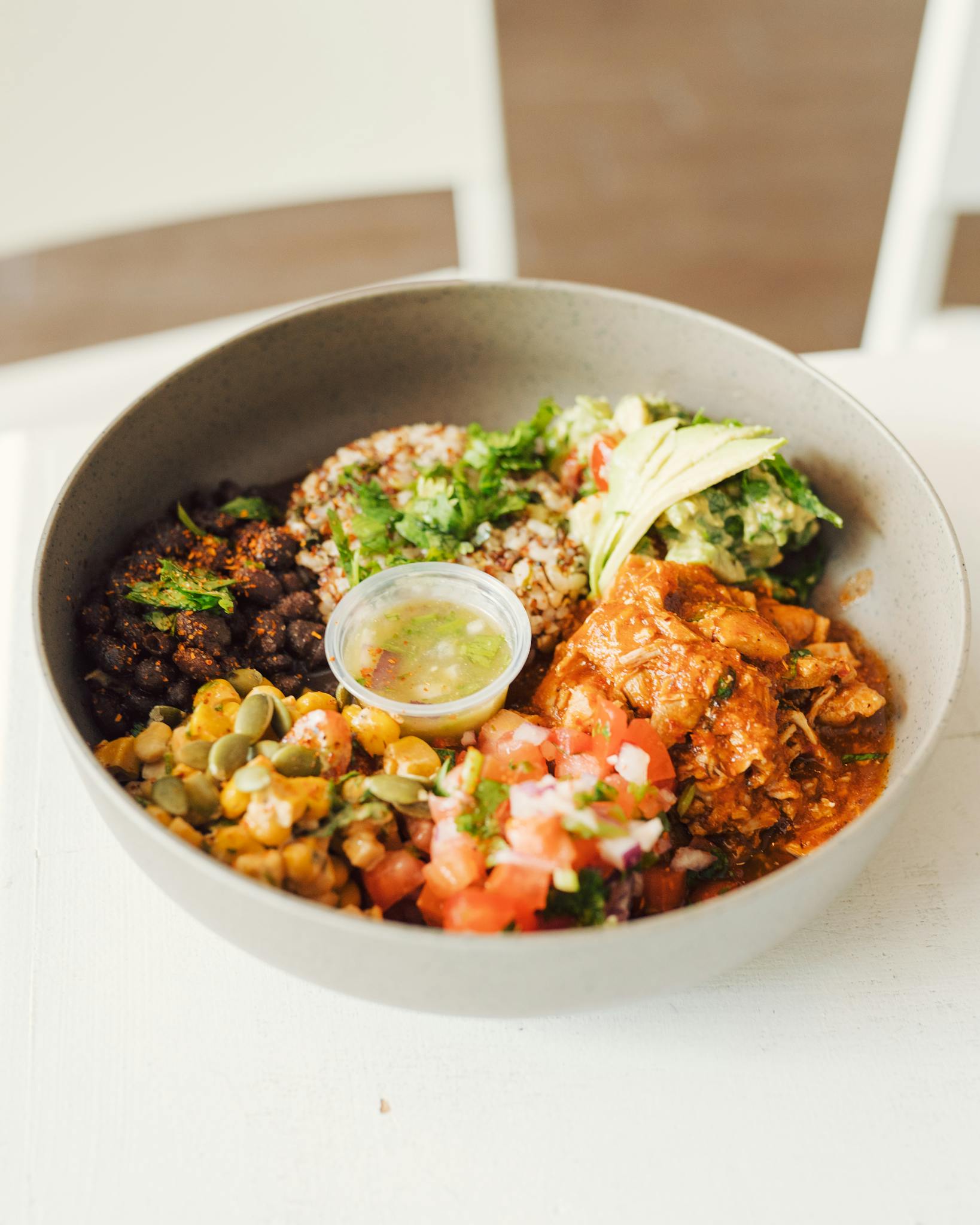 A vibrant Mexican salad bowl featuring avocado, chicken, beans, and salsa, perfect for a nutritious meal.