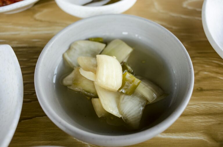 Close-up of a bowl with fermented vegetable soup, showcasing homemade pickled ingredients.